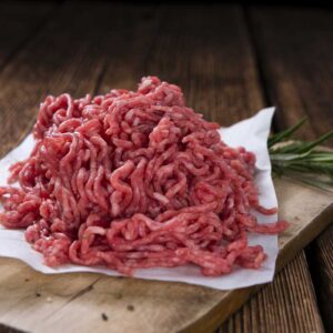 Ground meat on a wooden surface.