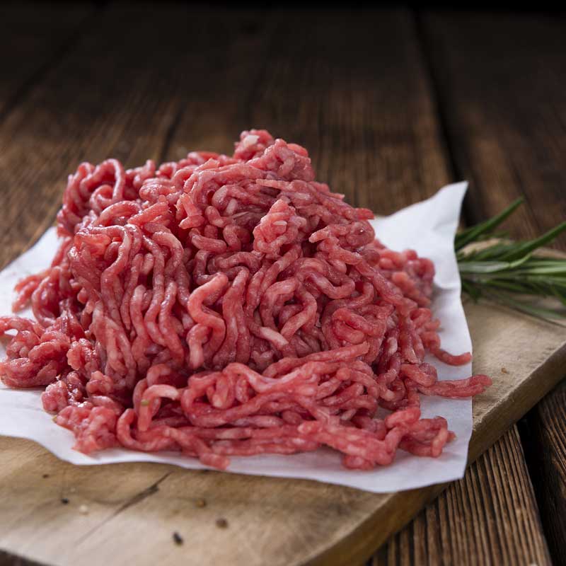 Ground meat on a wooden surface.