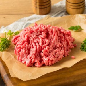 Raw ground meat on parchment paper.